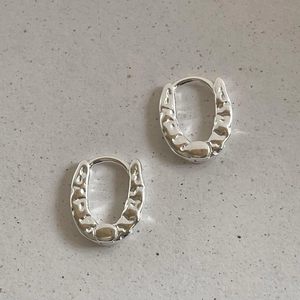 Detail of irregular hammer texture on 925 sterling silver hoop earrings in silver finish