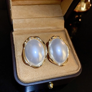Boucles d'oreilles ovales dorées vintage avec perles ivoire dans un écrin de luxe