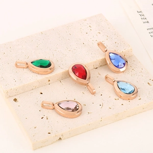 Detailed close-up of water drop crystal pendants in emerald, ruby, and sapphire colors