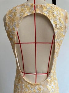 Detail of yellow floral lace dress featuring backless cutout design and 3D floral texture