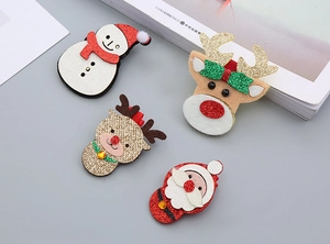 Détail de pinces à cheveux de Noël avec bonhomme de neige, renne et Père Noël en paillettes