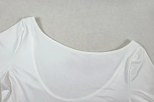 Close-up of the elegant round neckline and smooth fabric texture of the white mini dress