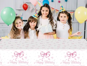 Detail of pink bow pattern and Happy Birthday lettering on disposable party tablecloth