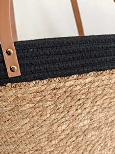 Large woven tote bag with black mesh upper and natural straw base for beach vacation