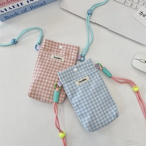 Gros plan de mini sacs en toile à carreaux rose et bleu avec lanyards réglables