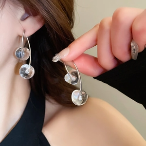 Close-up of elegant double clear cherry-shaped earrings with silver hooks for women