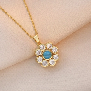 Rotating gold orchid pendant necklace with blue cat eye stone and white zircons