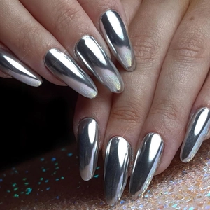Macro shot of long almond nails with silver metallic mirror finish and chrome effect