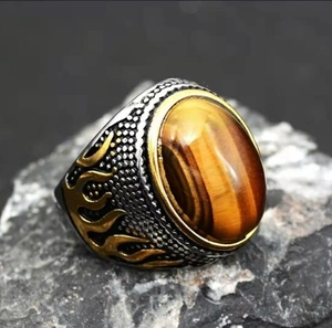 Macro detail of a vintage tiger eye ring with flame engravings on a raw stone