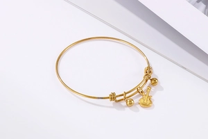 Close-up of golden guitar pendant and beads on an adjustable stainless steel bangle