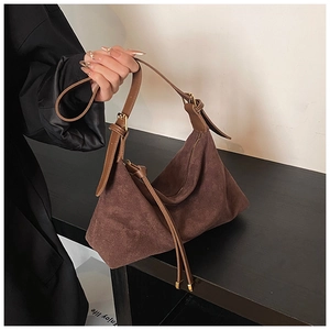 Detail of dark brown suede hobo bag with adjustable leather strap and gold hardware