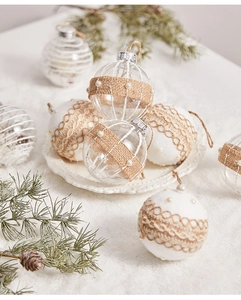 Close-up of clear and flocked Christmas balls with burlap lace and pearl accents