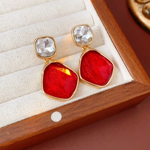 Macro de boucles d'oreilles vintage en or avec gemmes rouges et claires en boîte