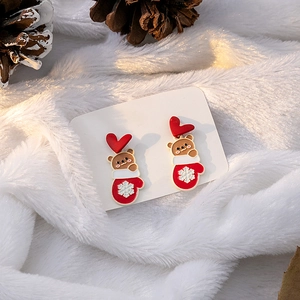 Detail of Christmas earrings featuring cute brown bears and red snowflake mittens