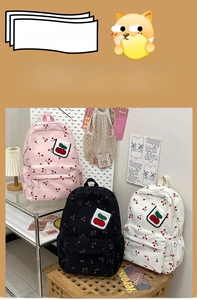 Dettaglio di zaini in velluto a coste rosa nero e bianco con ricamo a ciliegia