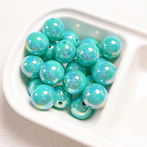 Macro shot of 14mm Tiffany blue UV-coated acrylic beads in a white ceramic dish