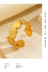 Close-up of golden interlocking heart-shaped ring on a textured stone surface