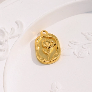 Macro detail of 18K gold plated oval pendant with embossed tulip floral design