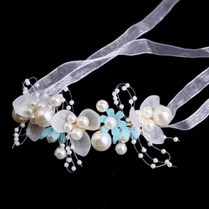Detail of bridal headband with pearls, frosted petals, and white organza ribbon