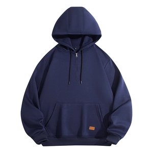 Detail of navy half-zip hoodie featuring a kangaroo pocket with a brown leather logo patch
