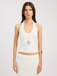 Detail of white knit halter top and ribbed skirt showing high-quality fabric texture