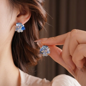 Elegant gold-plated butterfly stud earrings with blue crystals and pearl accents