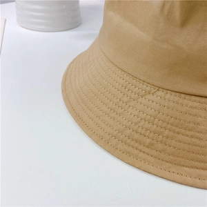 Macro shot of khaki bucket hat showing parallel stitching details and cotton canvas texture