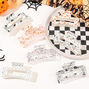 Flat lay of medium Halloween claw clips featuring pumpkins, ghosts and spider web patterns