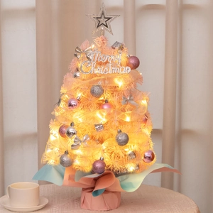 Close-up of pink mini Christmas tree with silver ornaments and glowing LED lights