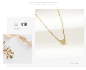 Detail of a gold heart pendant necklace featuring micro-set cubic zirconia on O-chain