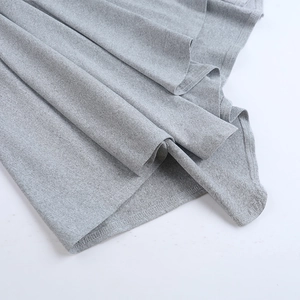 Detailed macro view of the grey knit skirt hem showing premium fabric texture and stitching