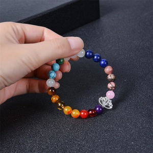 Detailed view of natural stone chakra beads bracelet with a silver lotus flower charm