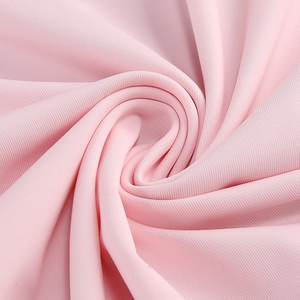 Vista macro del tessuto ricamato rosa con morbido drappeggio per abiti da sera