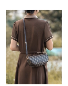 Detail of vintage brown saddle bag with geometric print worn by model outdoors