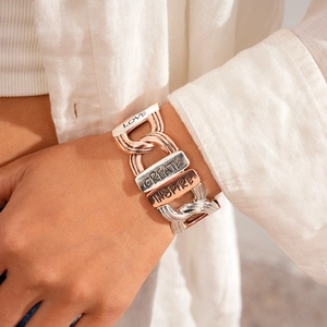 Detail of tricolor metal link bracelet with Love Create Inspire engraved plates