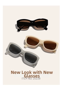 Close-up of rectangular vintage sunglasses in black, cream, and translucent grey finishes