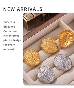 Macro detail of vintage floral relief stud earrings in gold and silver on velvet