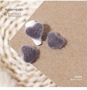 Detail view of 18mm grey plush heart nail charms and DIY sweater jewelry accessories