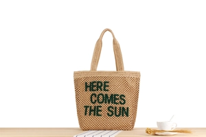 Détail du texte brodé HERE COMES THE SUN sur le sac cabas en paille tressée