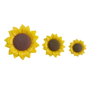 Three glossy resin sunflower DIY accessories in small, medium, and large sizes on white background