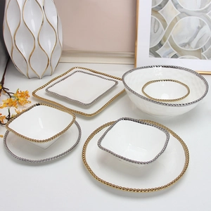 White ceramic dinnerware set with gold beaded rim featuring square and round plates