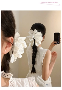 Close-up of white lace flower hair claw clip with pearl center on braided hair