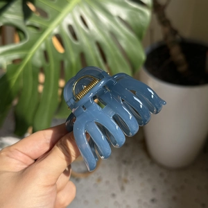 French style elegant blue pumpkin hair claw clip with golden spring held in hand