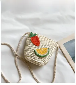 Dettaglio borsa a tracolla in paglia per bambini con carota e limone all'uncinetto