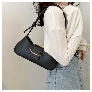 Detail of black matte leather underarm bag with gold metal buckle and knotted shoulder strap