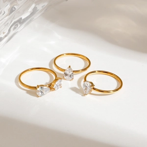 Three-piece gold stainless steel stacking rings featuring a pear-cut zircon gemstone