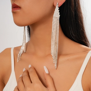 Close-up of sparkling long tassel rhinestone earrings on a model in silver finish