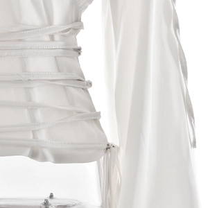 Détail d'un haut en satin blanc avec cordon de serrage à la taille et texture de tissu doux