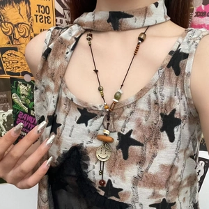 Detail of beaded long necklace featuring retro ceramic beads and a yellow smiley pendant