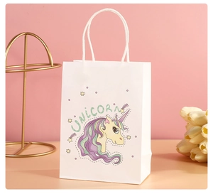 Detail of white paper gift bag with unicorn illustration and soft rope handle on pink background